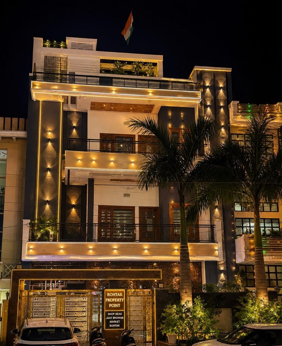 The Rohtak Property Point office in Market Sector 2, Rohtak, lit up at night, with the sign at the gate: Rohtak Property Point, shop near Jaat Bhawan Market